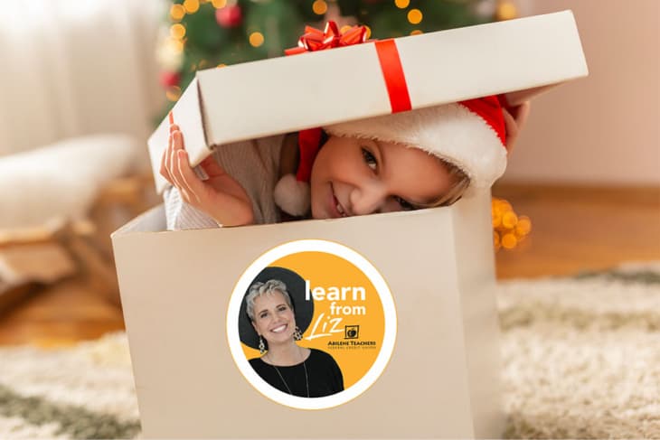 Niña asomándose desde el interior de un regalo de Navidad