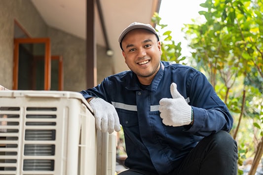 Air conditioner repairman giving the thumbs up sign.