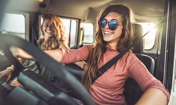 Interior photo of a young woman driving a big truck
