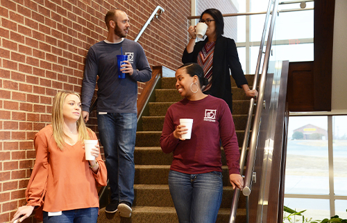 Four ATFCU employees descending staircase