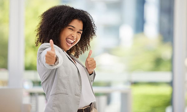 Happy young woman making thumbs up gesture