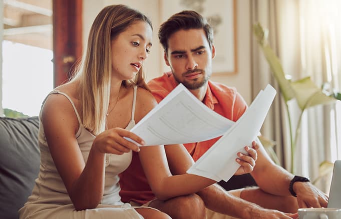 Young couple studying bills and budget