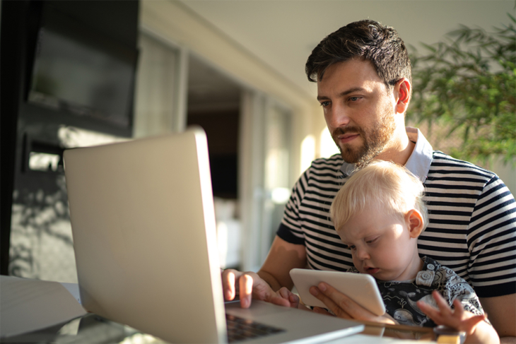 Male with child in his lap using a laptop computer