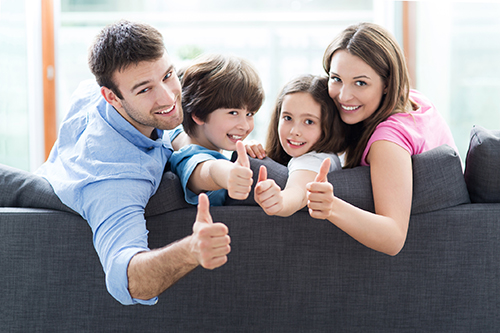 family on sofa with thumbs up