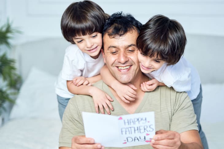 papá con dos hijos y tarjeta del día del padre