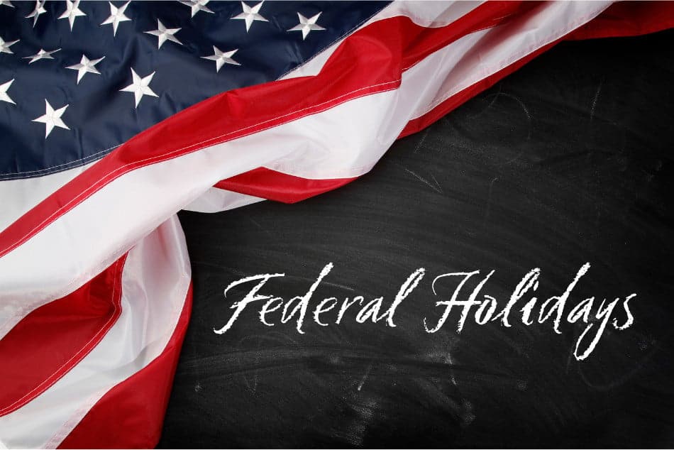 An American flag draped diagonally across a dark, textured background. The words 'Federal Holidays' are written in a flowing, white script font in the lower right portion of the image.