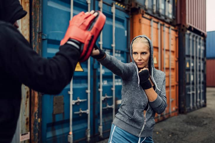 Woman boxing outdoors with her personal trainer