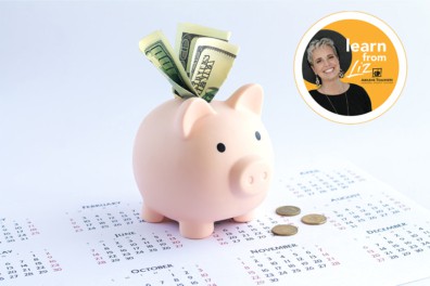 piggy bank on top of a calendar with money hanging out