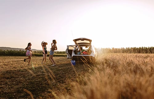 Family near car in plowed field