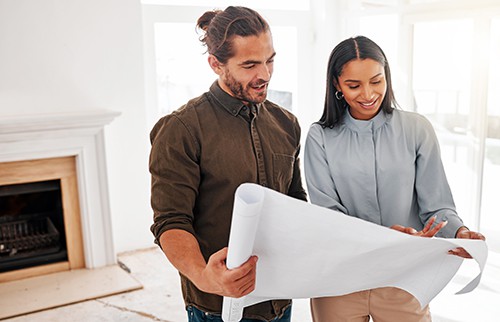 Husband and wife looking at plans for home remodel.