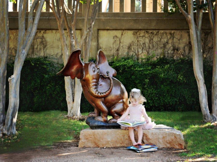 Little girl reading in sculpture park