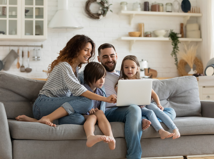 Family on couch looking at laptop computer