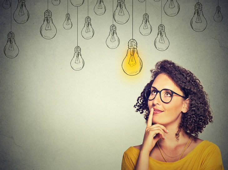 Woman thinking and making a choice between several lightbulb choices