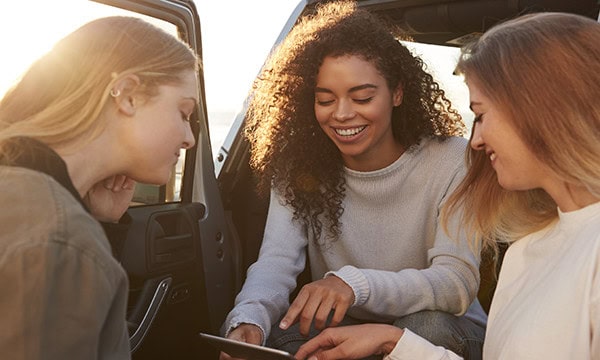 Three young women making plans for a road trip