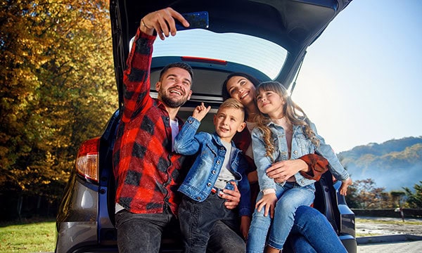 Family taking selfie sitting in the back of their SUV