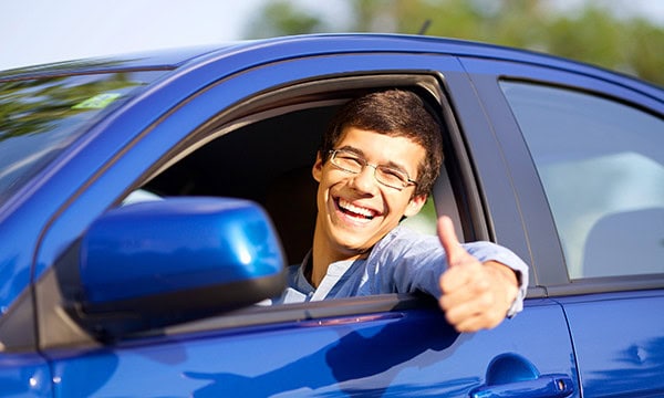Man giving a thumbs up sign while leaning out of driver's window