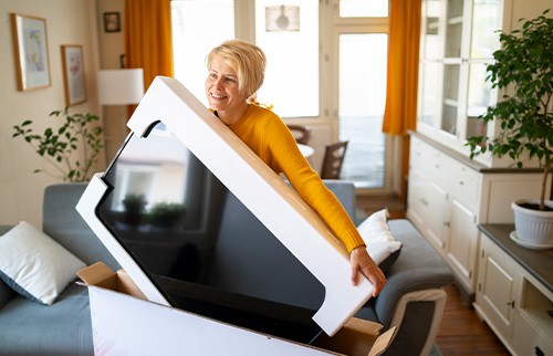 woman holding large television