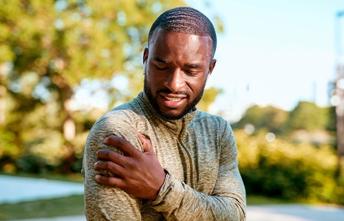 african american man holding his shoulder