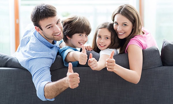 Family of four giving the thumbs up sign