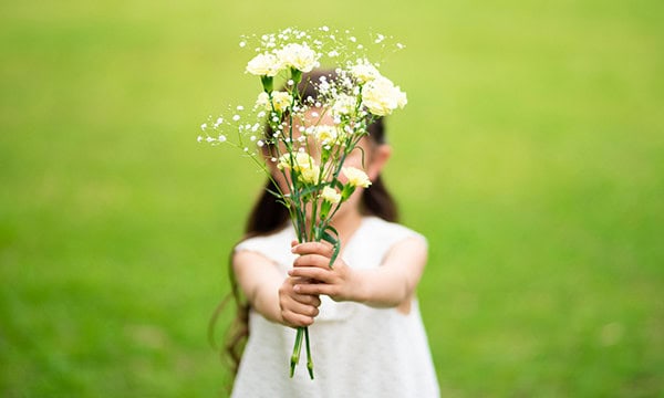 Young child offering a bouquet of flowers