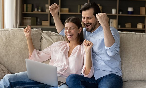 Happy couple viewing a laptop screen