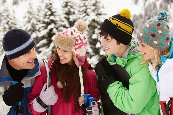Group of happy teenagers talking on a ski vacation