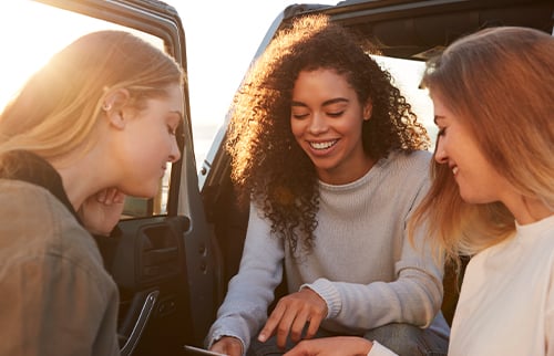 Three girlfriends planning roadtrip