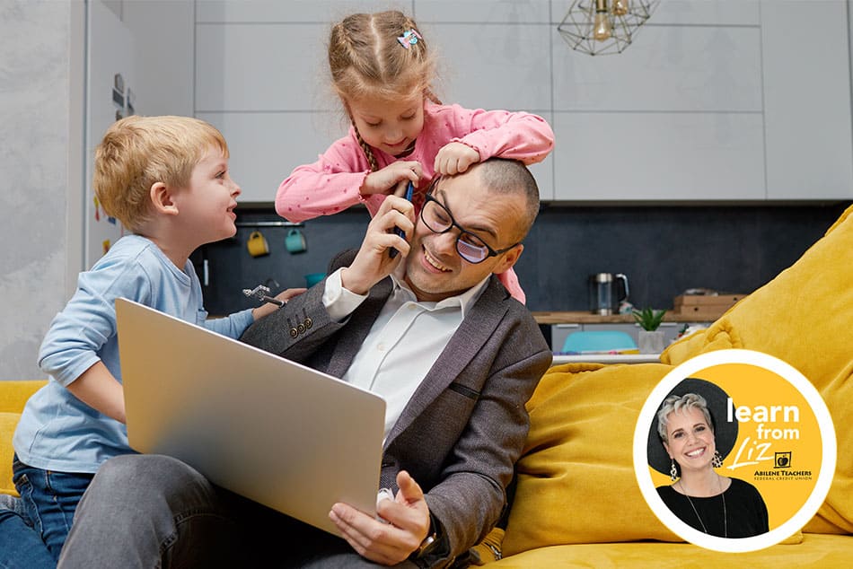 dad on laptop with kids crawling over him