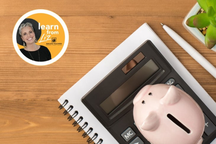 notebook, calculator, piggy bank and pen sitting on table