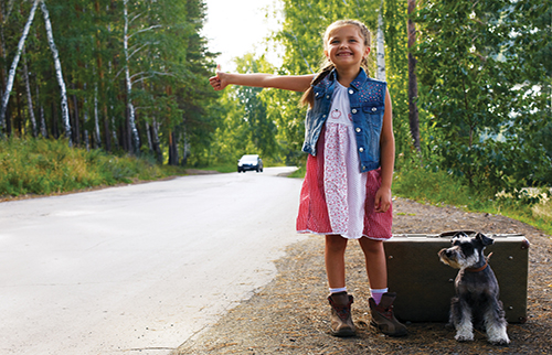 Young girl playfully hitchhiking