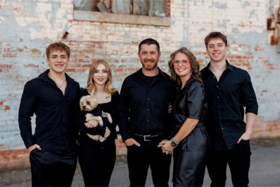 family standing infront of a brick wall with a yorkie