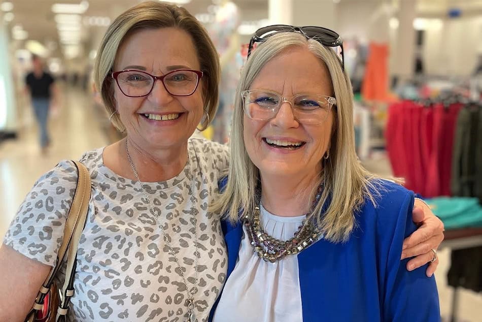 TWO WOMEN SMILING IN A DEPARTMENT STORE