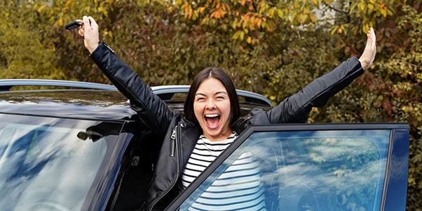 Young woman excited about her new car