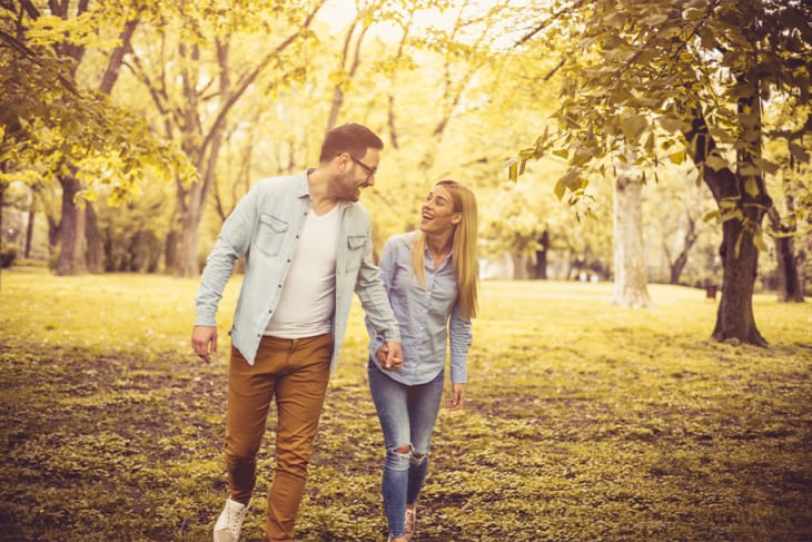 man and woman holding hands walking