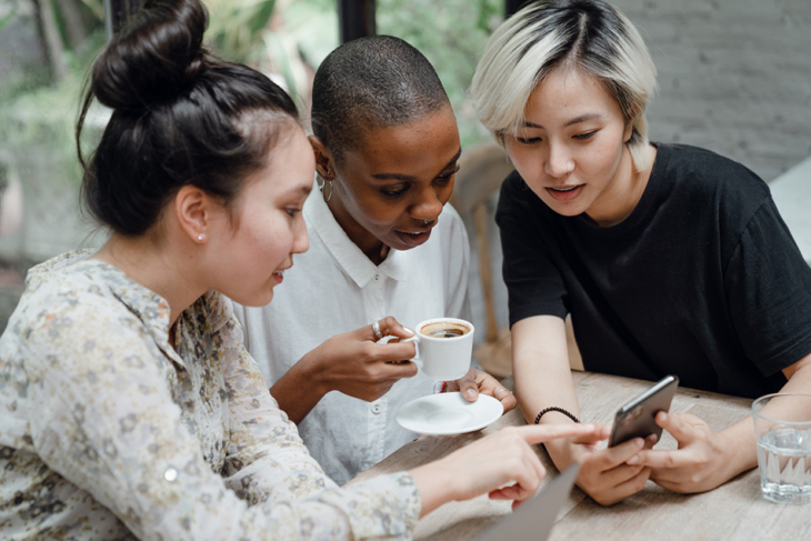 Three women at table discussing results