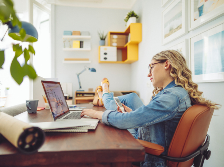 Woman using laptop and cell phone at same time