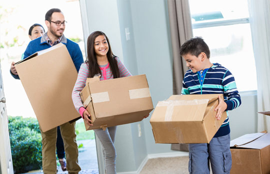 family moving boxes to new home