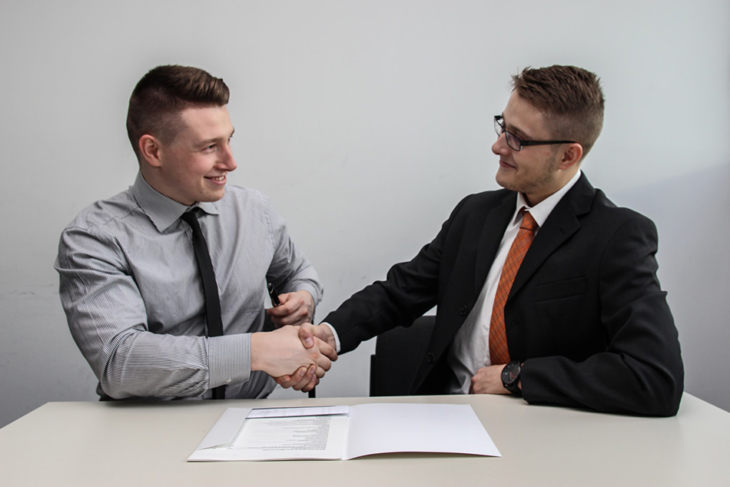 Two young men shaking hands on a deal