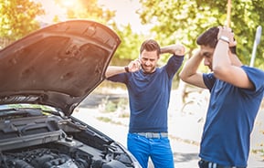 To men looking at broken down car