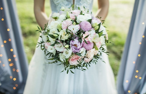 girl in wedding dress holding flowers