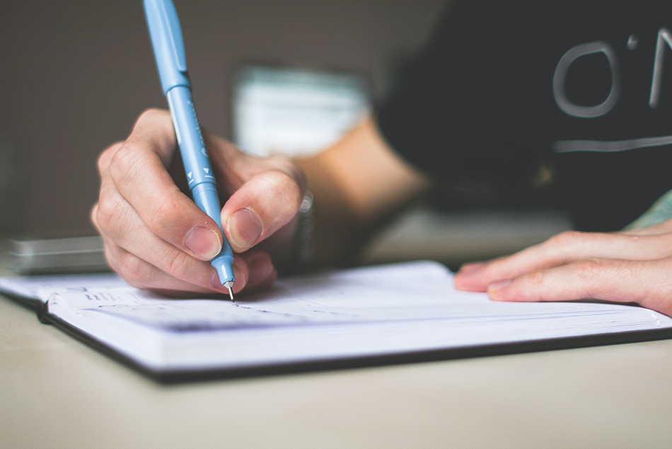 Teen writing in notebook