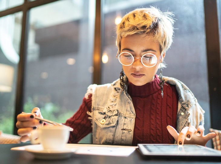 student on tablet at cafe