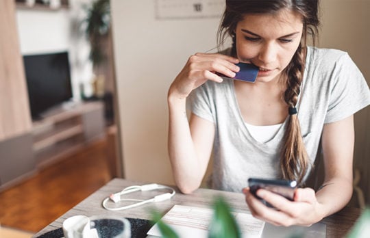 woman using credit card on smartphone